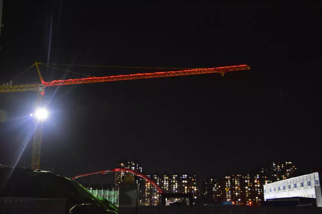     工地上的塔吊伸出长长的臂膀,掩着远处